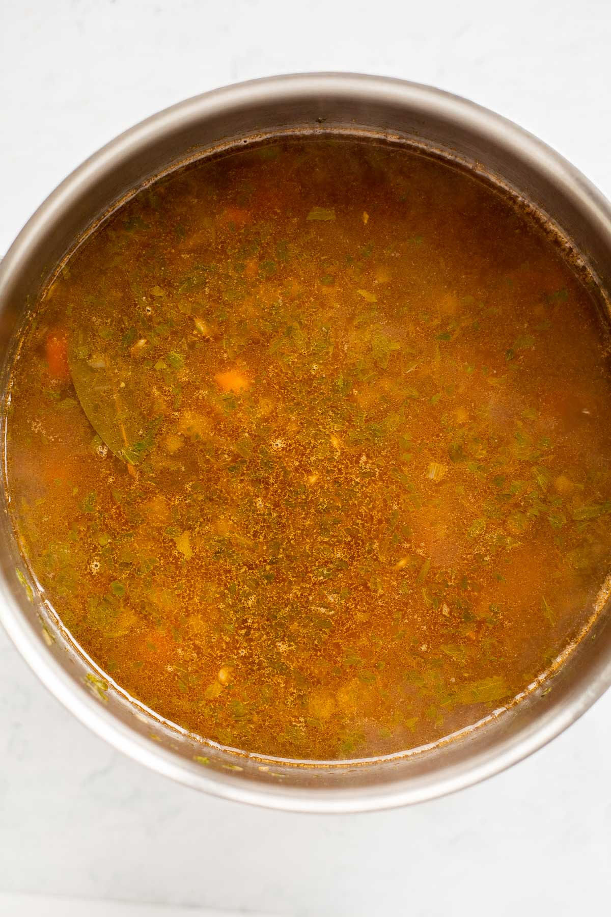 Broth in a stock pot for Greek lentil soup.