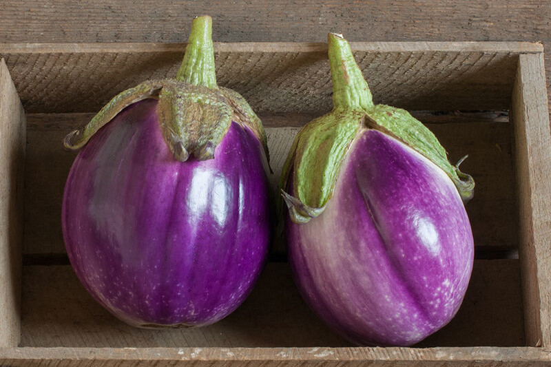 Two Rosa Bianca eggplants in a wooden box.