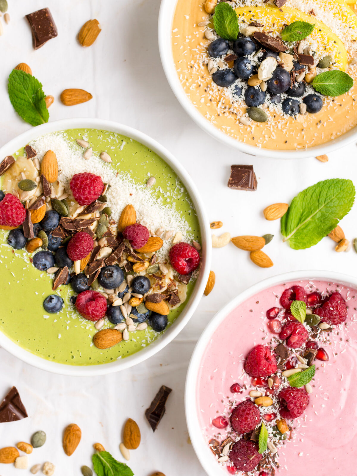 A variety of smoothie bowls on a while background.
