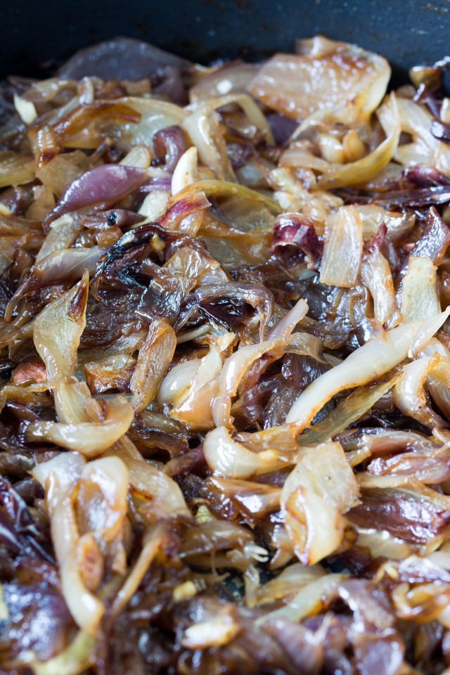 Caramelized red and white onions in a black frying pan.